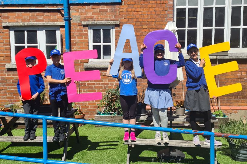 Children holding PEACE cutouts