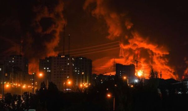Billowing flames over an oil terminal in a night sky