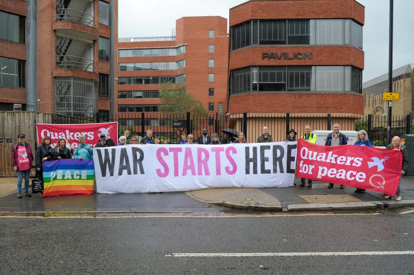 People holding long banner reading War Starts Here