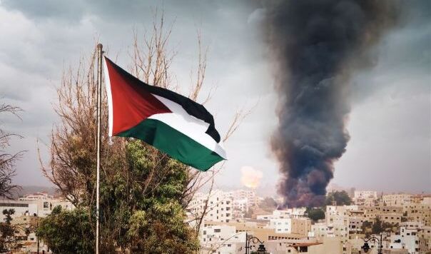 Palestinian flag flying before burning city