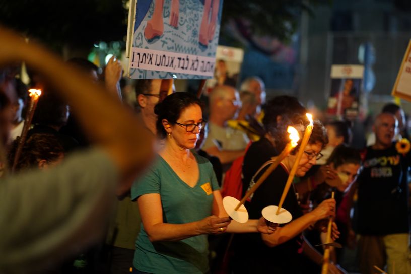 Woman holding candles in front of banner