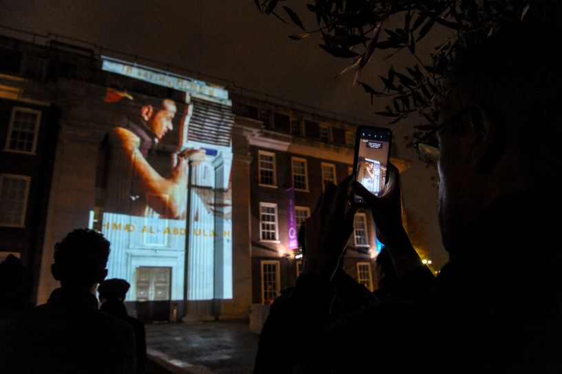 Projection of face on front of building in darkness