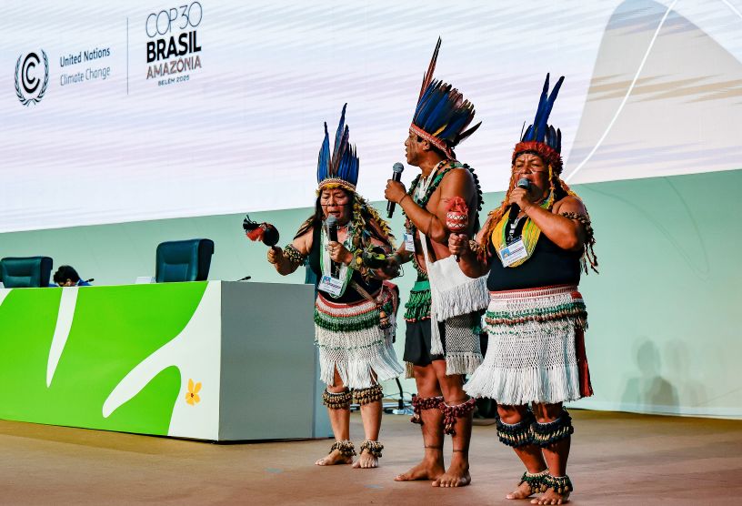 3 men dressed in traditional Brazilian dress on a platform