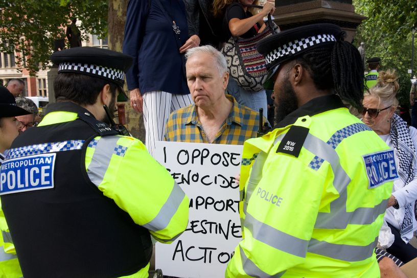 policemen and man holding placard