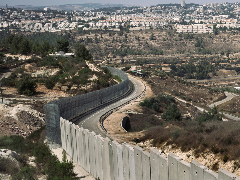 Big concrete wall dividing two areas of land