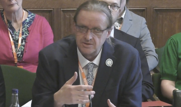 Man in tie and jacket speaking on panel