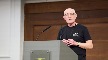 Stuart Masters stands behind a lectern, speaking, as he gives the Swarthmore lecture