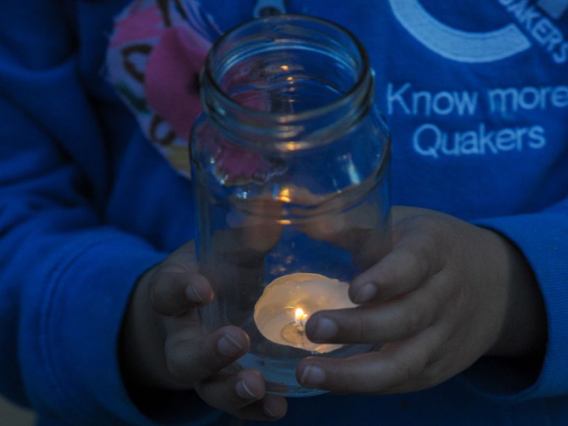 small hands holding a candle in a jar