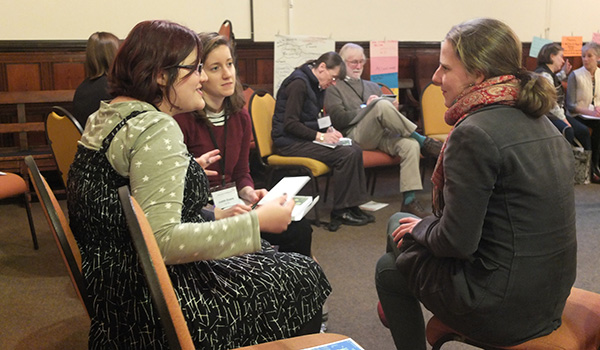 A group of young adults sitting in a discussion circle at a workshop.