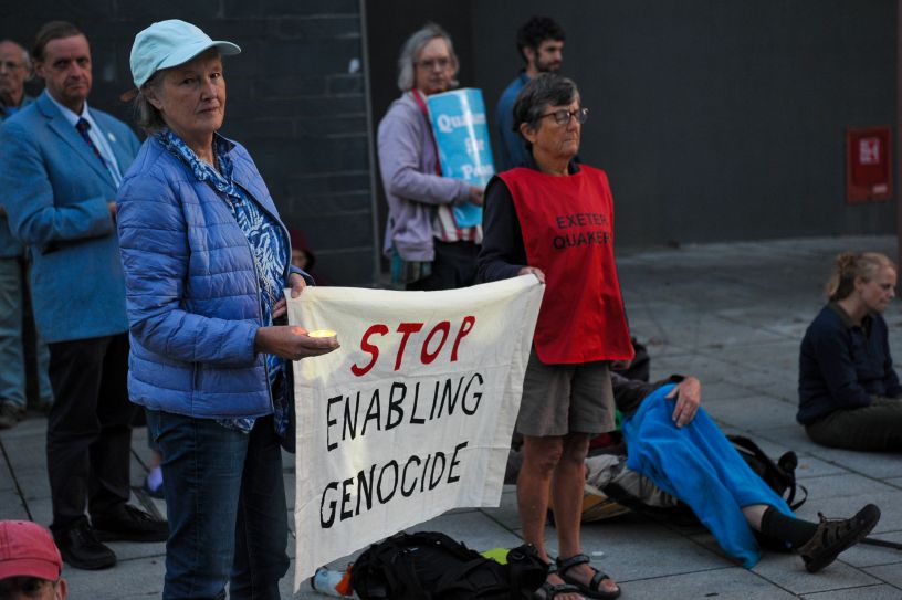 Two people holding a banner saying Stop Enabling Genocide