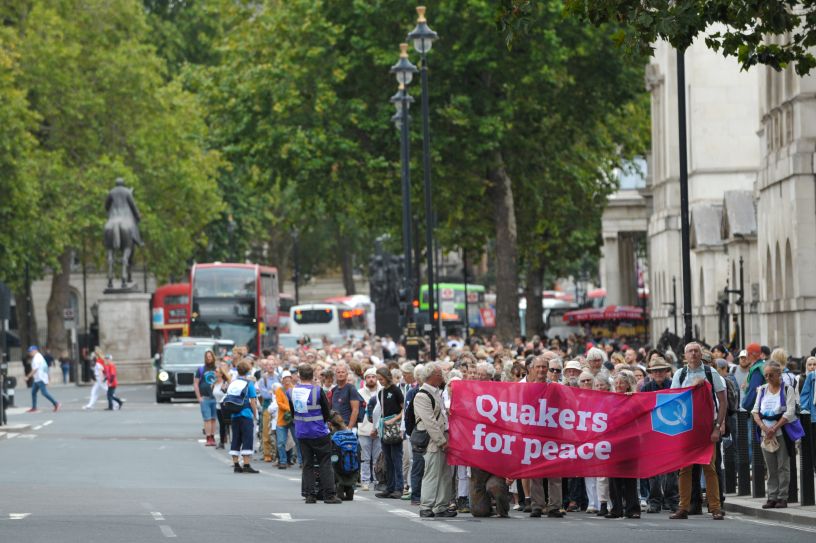 Quaker peace banner and crowd walking down Whitehall